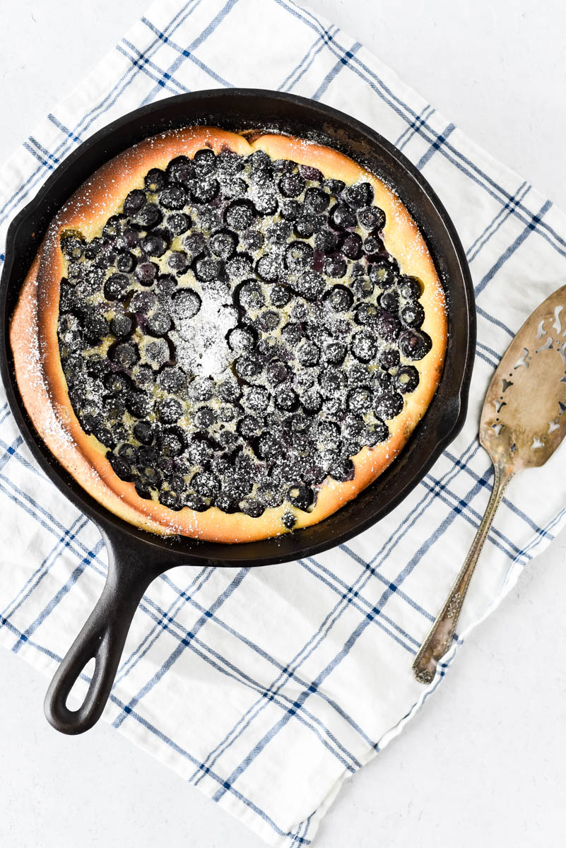 cast iron skillet with clafoutis and blueberries