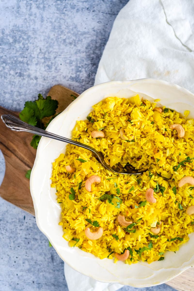 overhead view of lemon rice in white bowl with spoon