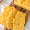 slices of mealie bread fanned out on cutting board beside loaf