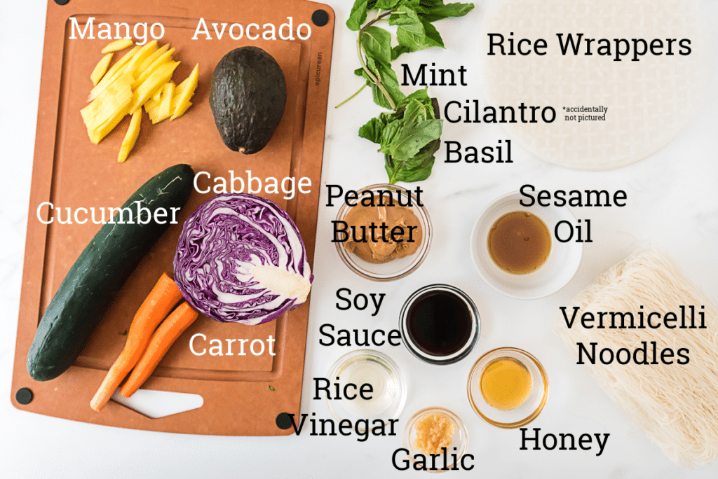 ingredients for spring rolls and peanut dipping sauce on marble counter with text overlay